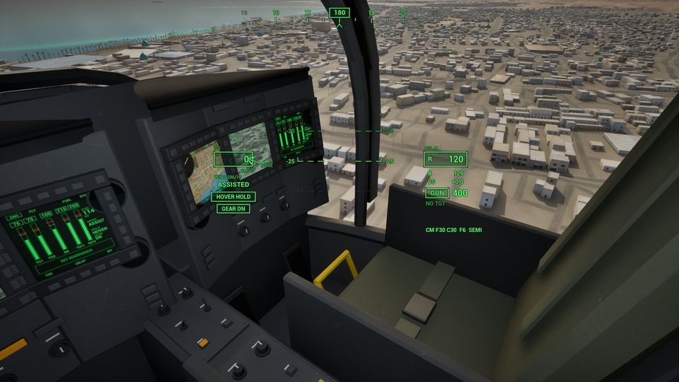 Inside the naval attack helicopter, looking right past the copilot's seat and the screens to the town below